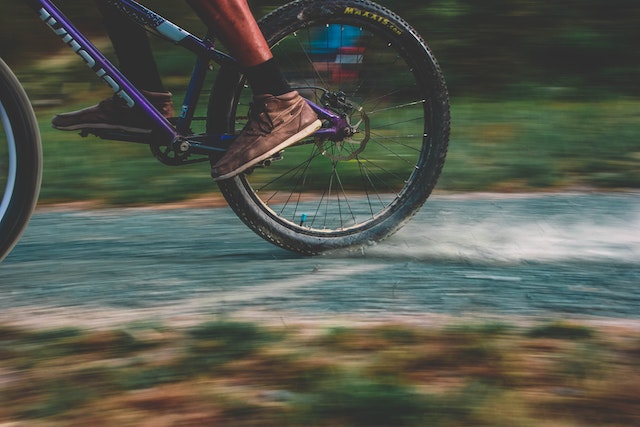 close-up of running shoes and bicycle on a paved street